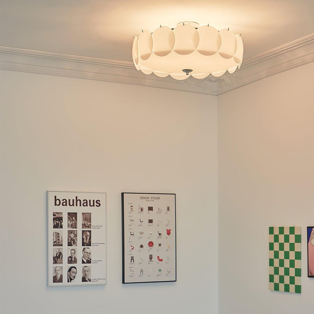 The Clérachic overlapping glass disc semi-flush ceiling light lit in a room with a Bauhaus poster and a chair-design print.