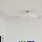 The Clérachic overlapping glass disc semi-flush ceiling light lit above a corner with checkerboard and portrait artwork.