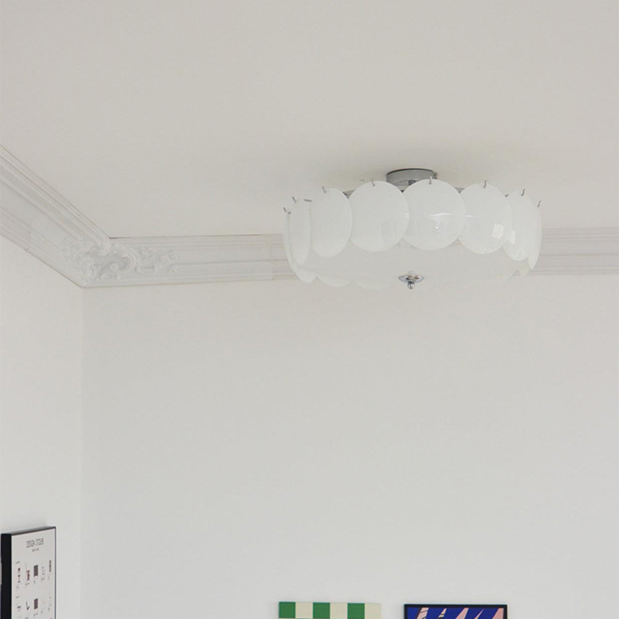 The Clérachic overlapping glass disc semi-flush ceiling light lit above a corner with checkerboard and portrait artwork.