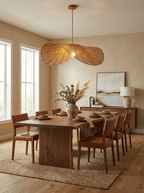 Above a long dark-wood dining table with jute rug and matching chairs, this Clérachic pendant glows warm.