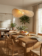 Over a dining table set with a fruit bowl and plates, this Clérachic pendant lights a plant-filled room.