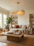 In a living room corner with built-in shelving and potted plants, this Clérachic pendant glows above a coffee table.