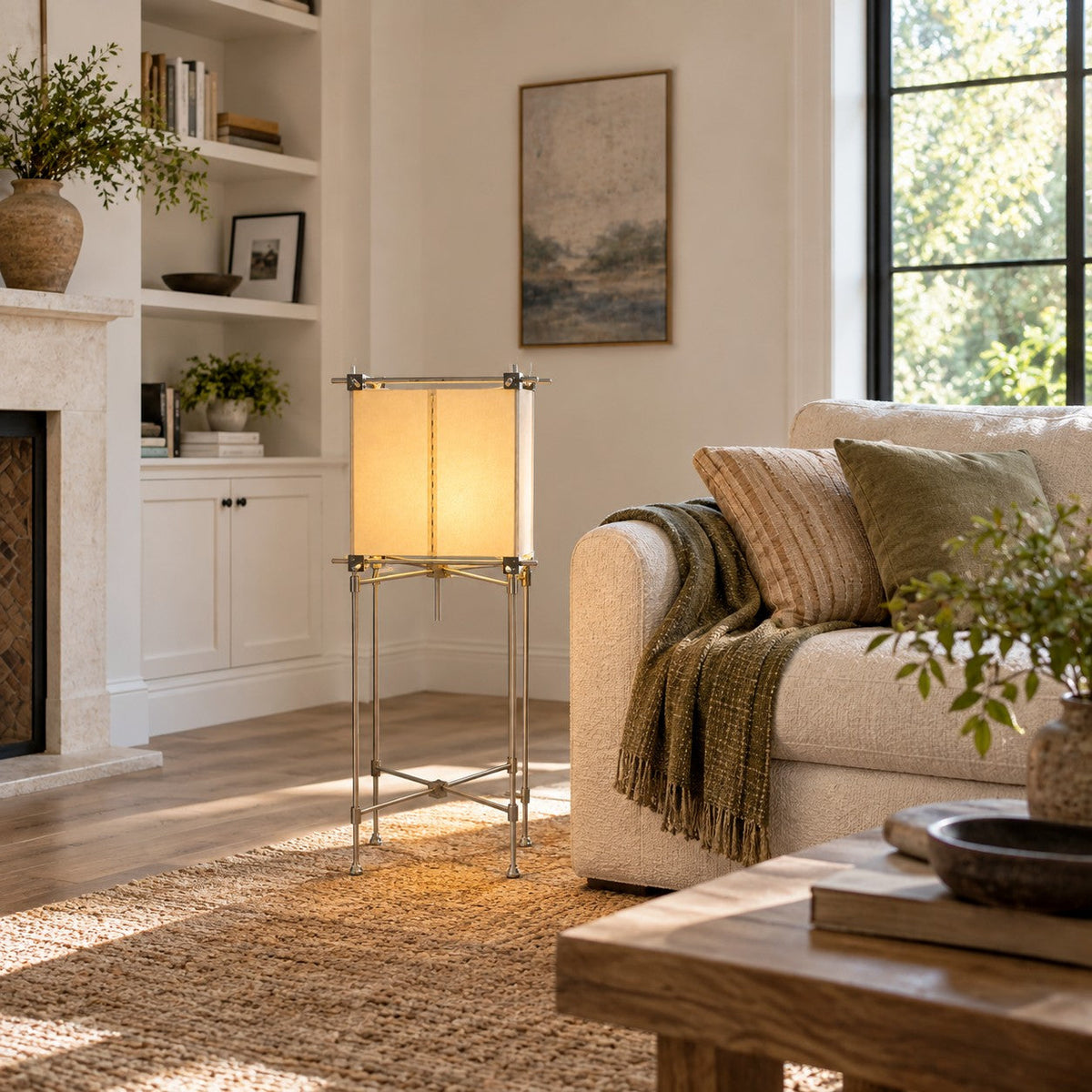 This Clérachic cube floor lamp stands before built-in white shelves, with a cream sofa and a rustic wood coffee table in sunlight.