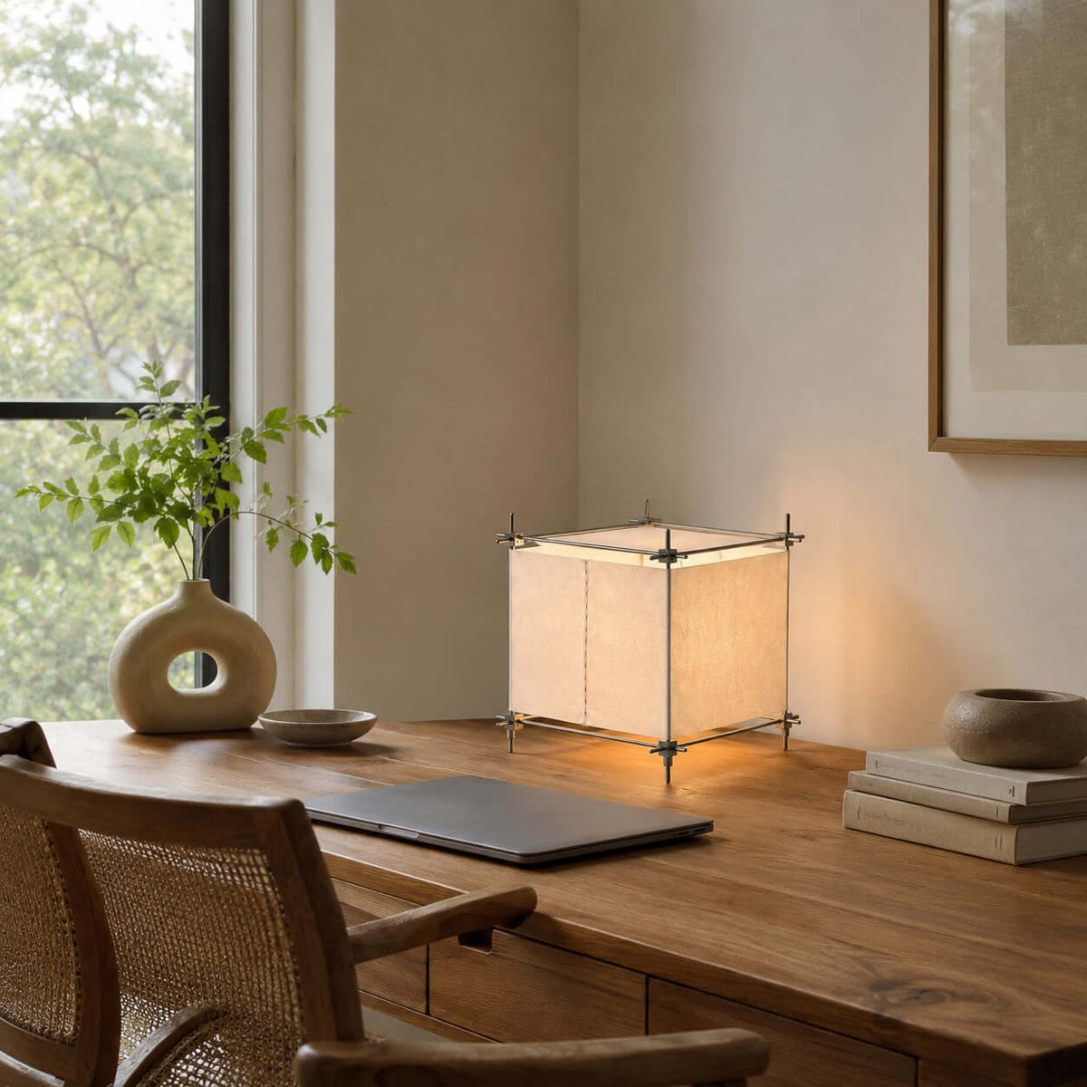 Beside a laptop and a stack of books on a wooden desk by the window, this Clérachic cube lamp glows in a corner.
