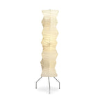 A Clérachic tall washi paper floor lamp on a white background, its creased pale shade on three thin black iron legs.