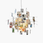 Cards printed with letters, birds and fruit hang from wire arms around the light on this Clérachic paper pendant, shown on white.