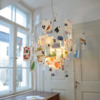 Lit from within, this Clérachic paper pendant hangs by tall sash windows with illustrated alphabet cards clipped to its wire arms.