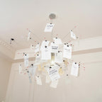 Under a cornice and a high plaster ceiling, this Clérachic paper pendant fans out cards on thin wire arms around a glowing core.