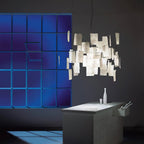 Against a dark wall and a blue glass-block window, this Clérachic paper pendant glows with clipped handwritten notes.