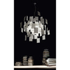 On a black background above stacks of books, a Clérachic paper pendant glows with handwritten notes.