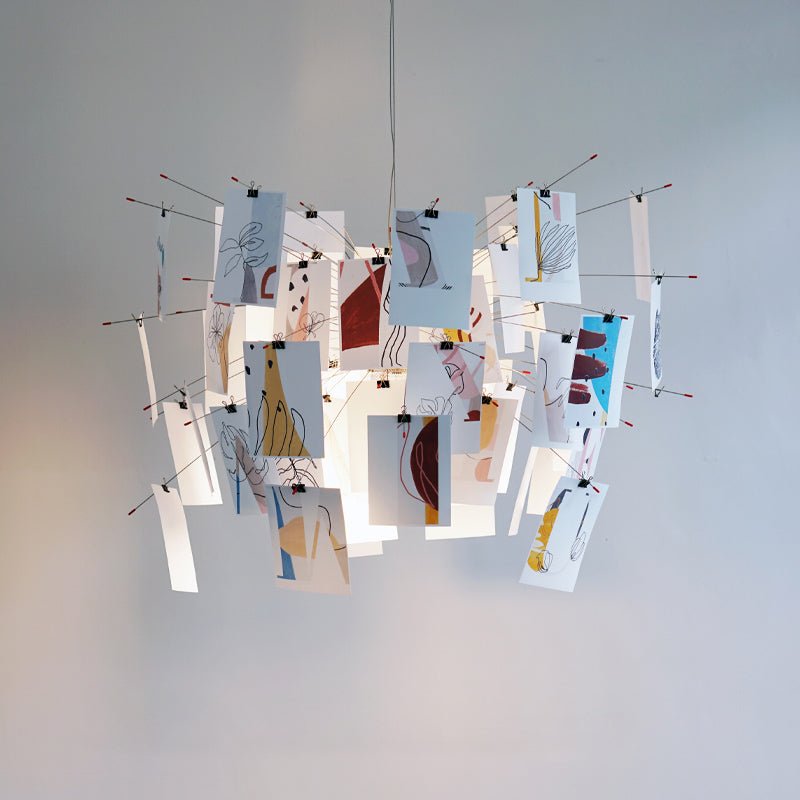 Abstract line drawings in red, tan and blue decorate the cards of this Clérachic paper pendant, seen from the side.