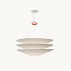 This Clérachic pendant has three stacked white paper cones hung on fine cables, with a red ring above, on a plain white backdrop.