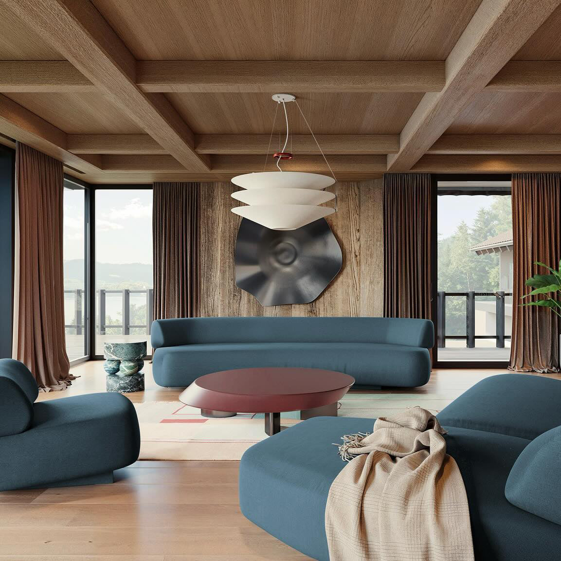 A Clérachic tiered white pendant hangs on cables under a beamed timber ceiling above blue sofas and a low red table.
