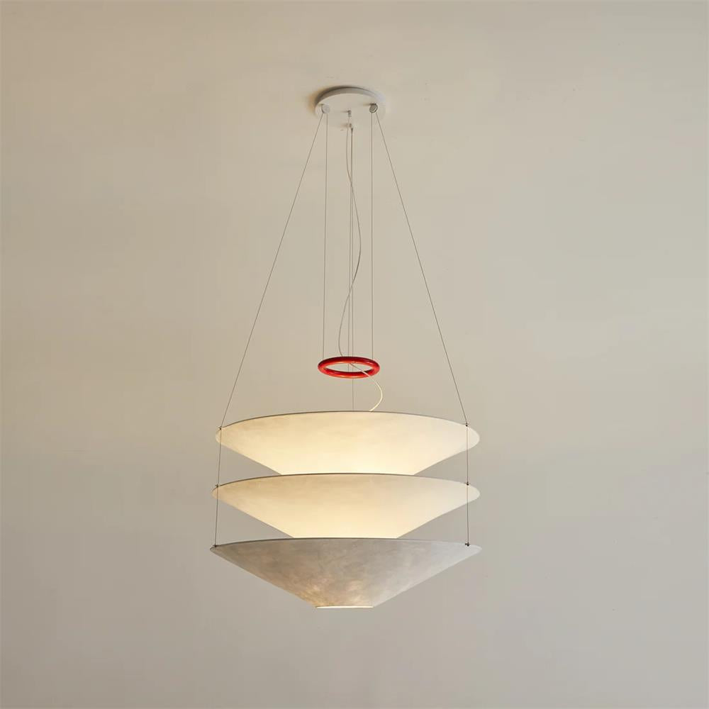 Lit from inside, this Clérachic three-tier pendant glows softly beneath a white ceiling plate, with a red ring on its cables.