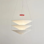 This Clérachic pendant has three widely spaced paper cones joined by fine cables, shown glowing against a plain pale wall.