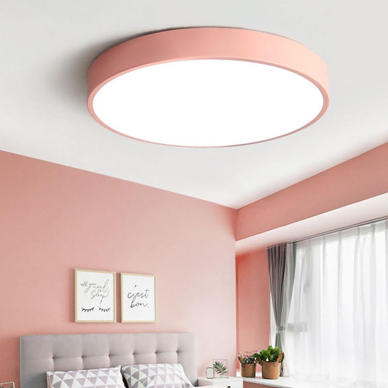 This blush-pink Clérachic flush mount ceiling light brightens a rosy bedroom with a tufted grey headboard.