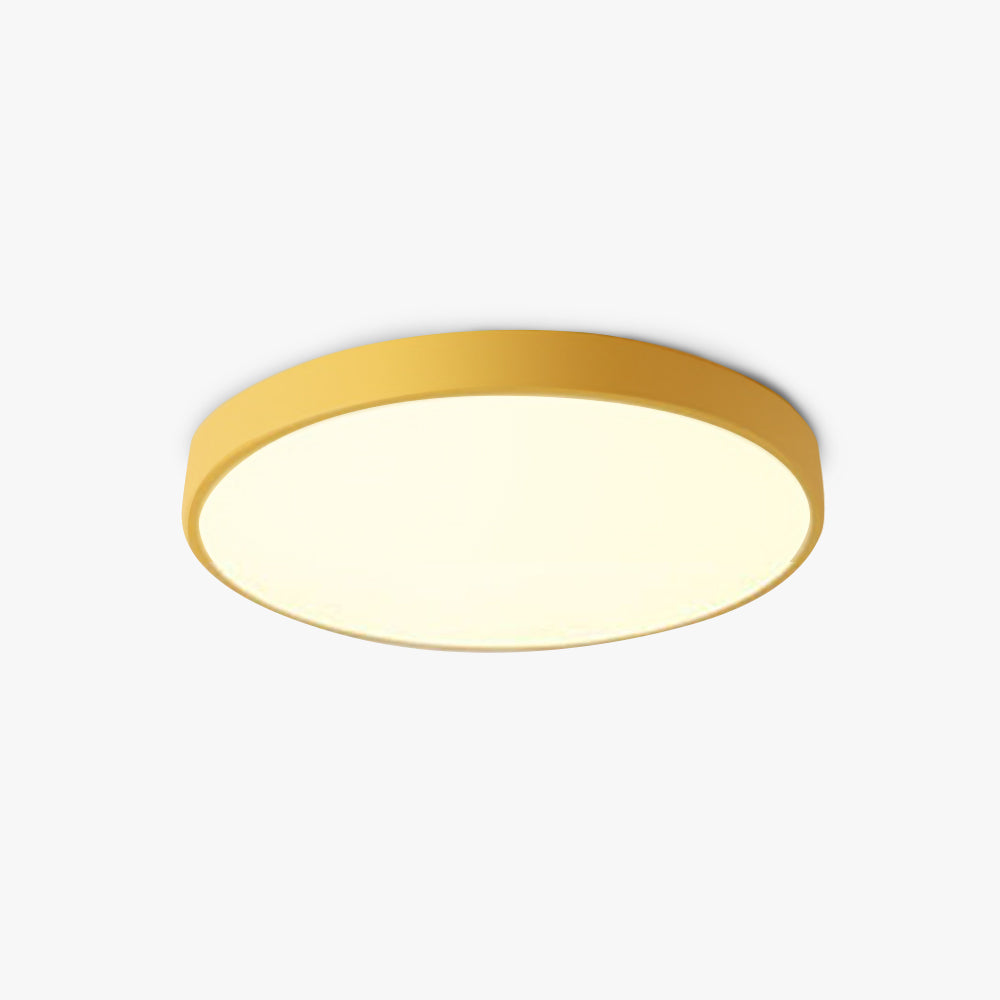 This mustard-yellow Clérachic flush mount ceiling light is pictured at an angle, showing its slim drum profile.