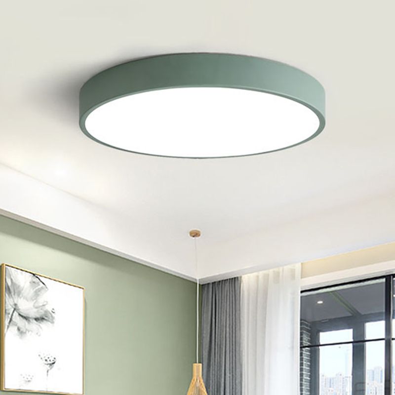 A sage-green Clérachic flush mount ceiling light is mounted in a green bedroom with sheer curtains and framed art.