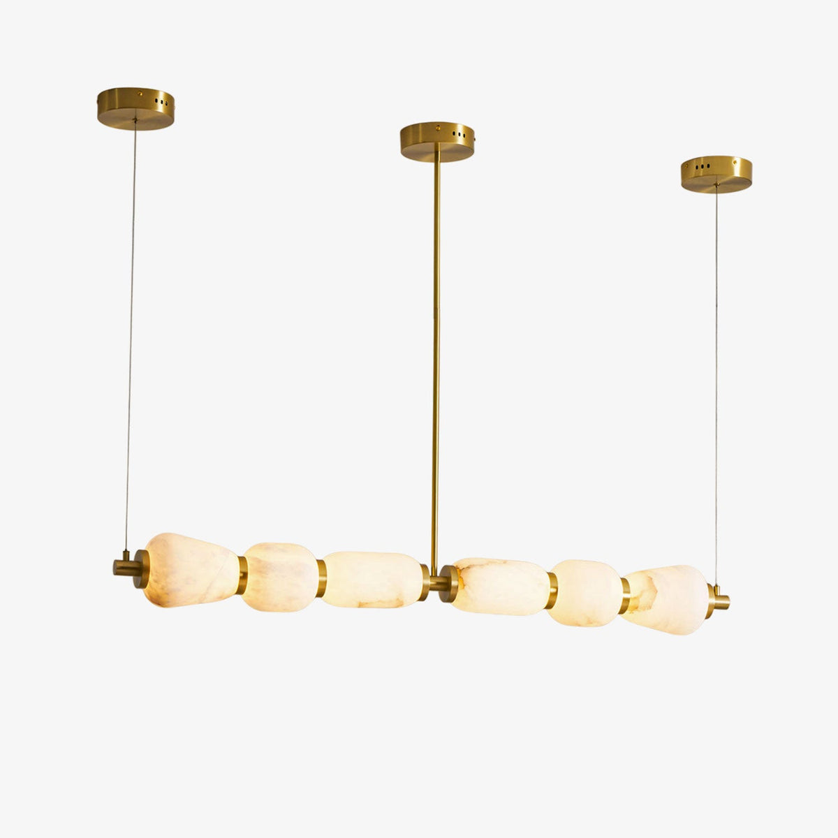 Six alabaster pebbles in a row on this Clérachic linear chandelier, hung from three gold canopies on a plain white background.