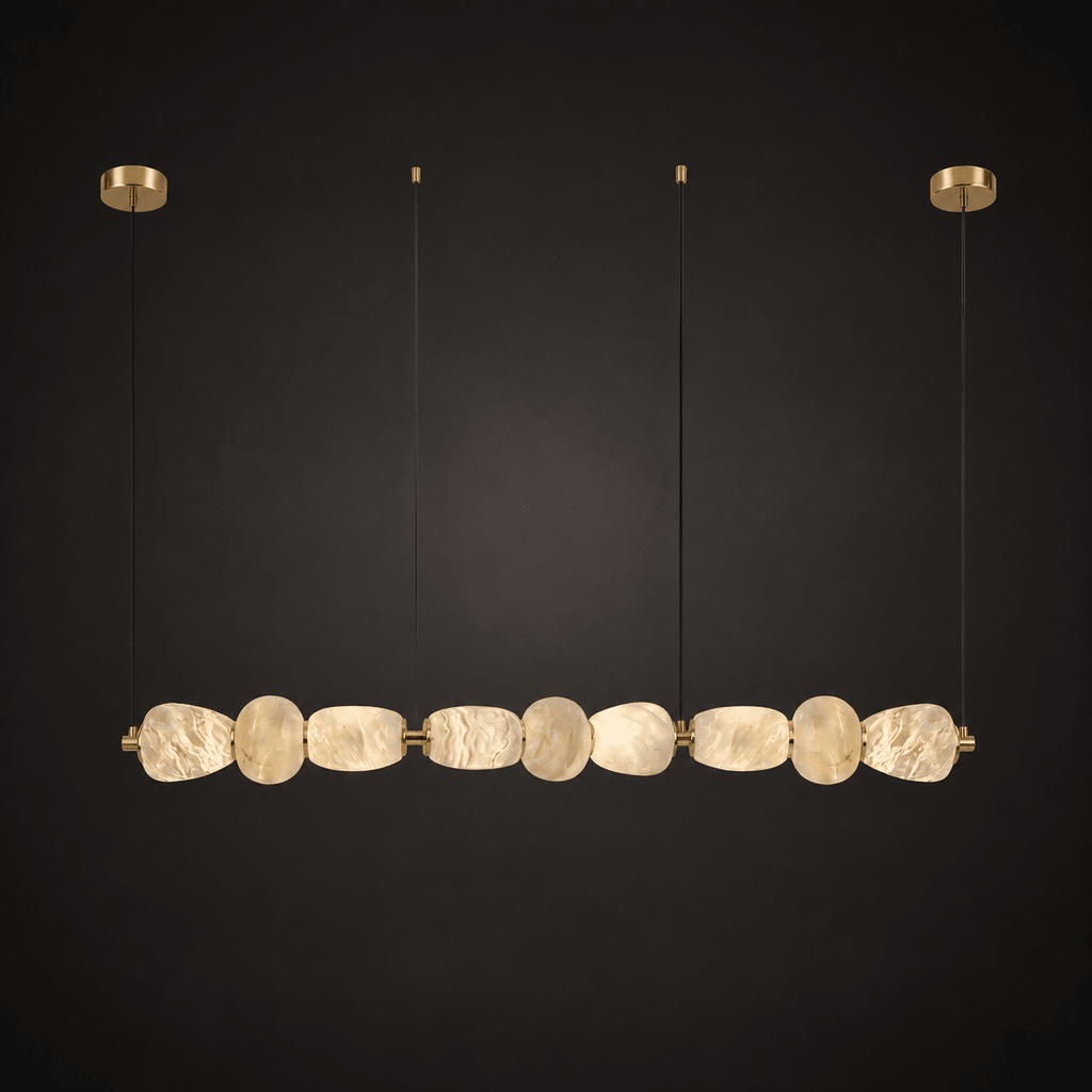 Clérachic gallery view of nine flat, rough-hewn stone pebbles strung in a long row below gold canopies, against a near-black background.