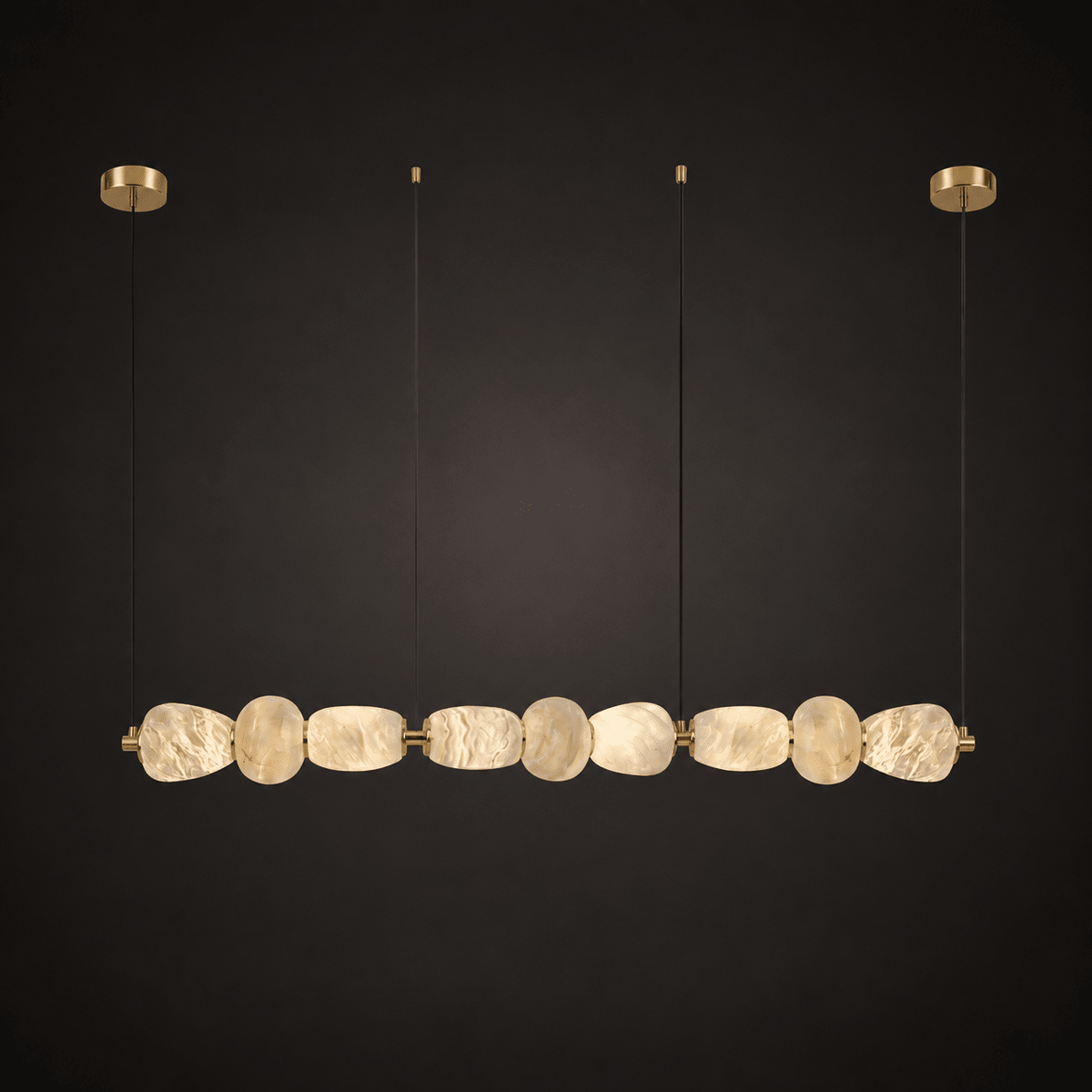 Clérachic gallery view of nine flat, rough-hewn stone pebbles strung in a long row below gold canopies, against a near-black background.