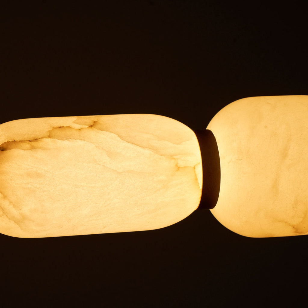 Close view of the glowing veined alabaster on this Clérachic chandelier, with a dark band between pebbles.