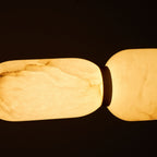 Close view of the glowing veined alabaster on this Clérachic chandelier, with a dark band between pebbles.