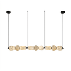 Clérachic gallery view of nine flat stone pebbles in a line, hung from two black canopies and fine cords, on a plain white background.