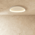 Clérachic white aluminium ceiling light with a soft oval outline, its inner rim glowing warm on a plaster ceiling.