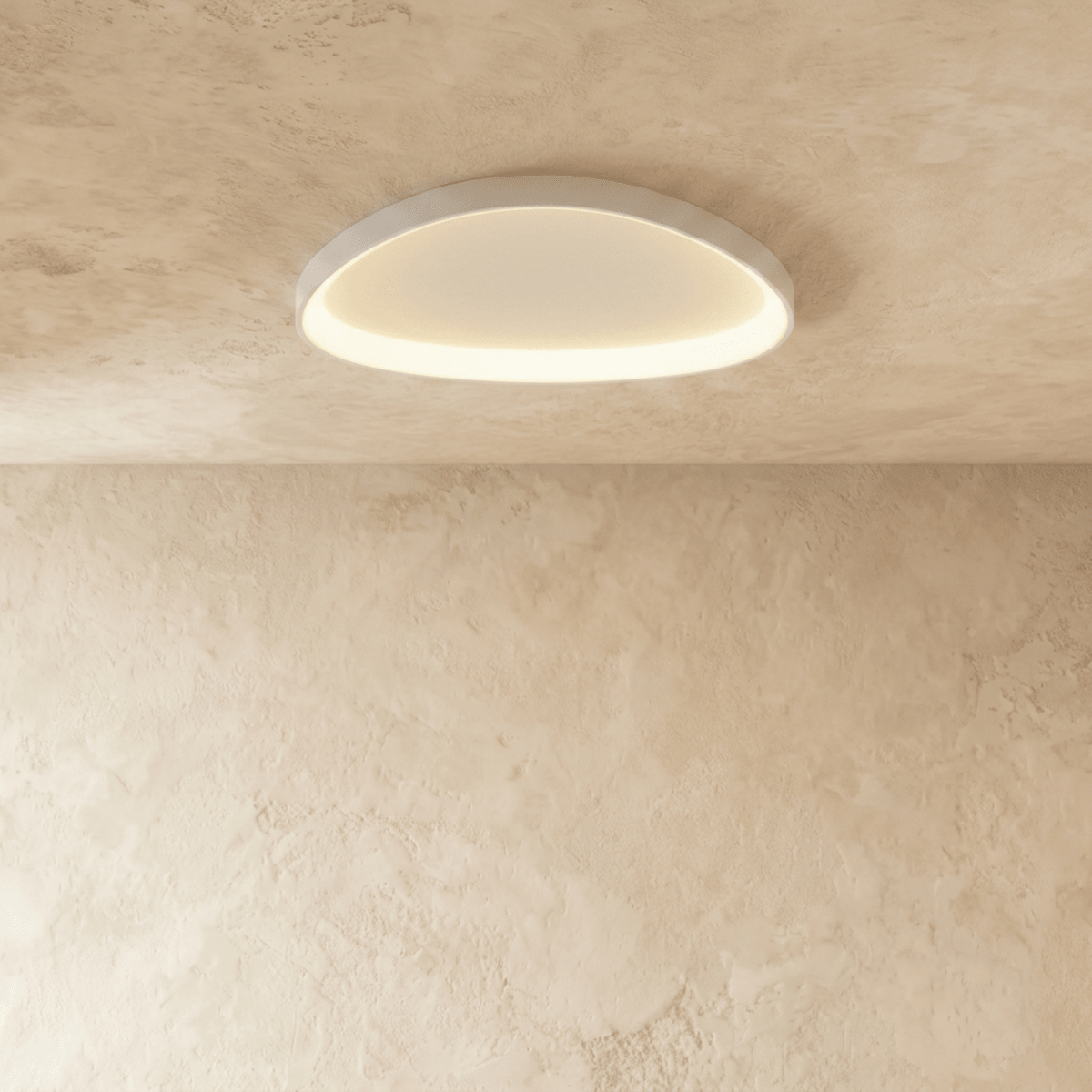 Clérachic white aluminium ceiling light with a soft oval outline, its inner rim glowing warm on a plaster ceiling.