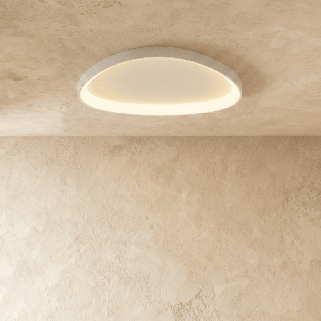Clérachic larger white aluminium ceiling light, flush-mounted and glowing evenly against a textured limewash ceiling.
