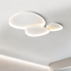 Clérachic three overlapping white pebble ceiling lights lit warm in a bright room with a recessed cove light below.
