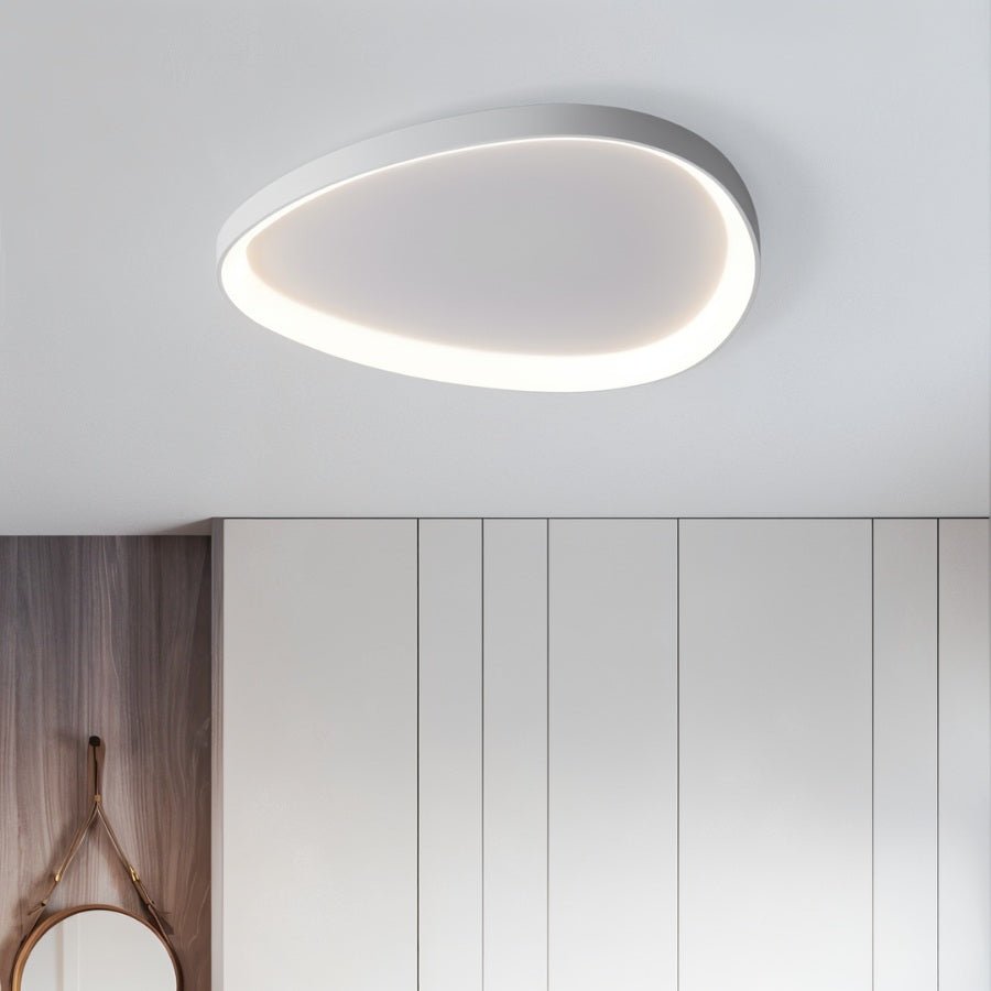 Clérachic white teardrop-shaped ceiling light glowing around its rim above white wardrobes and a round hanging mirror.