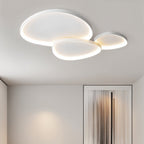 Clérachic cluster of three white ceiling lights lit warm in a hallway with a fringed curtain panel on the far wall.