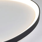 Close-up of the Clérachic black aluminium ceiling light rim, its slim edge framing a soft glowing white diffuser.