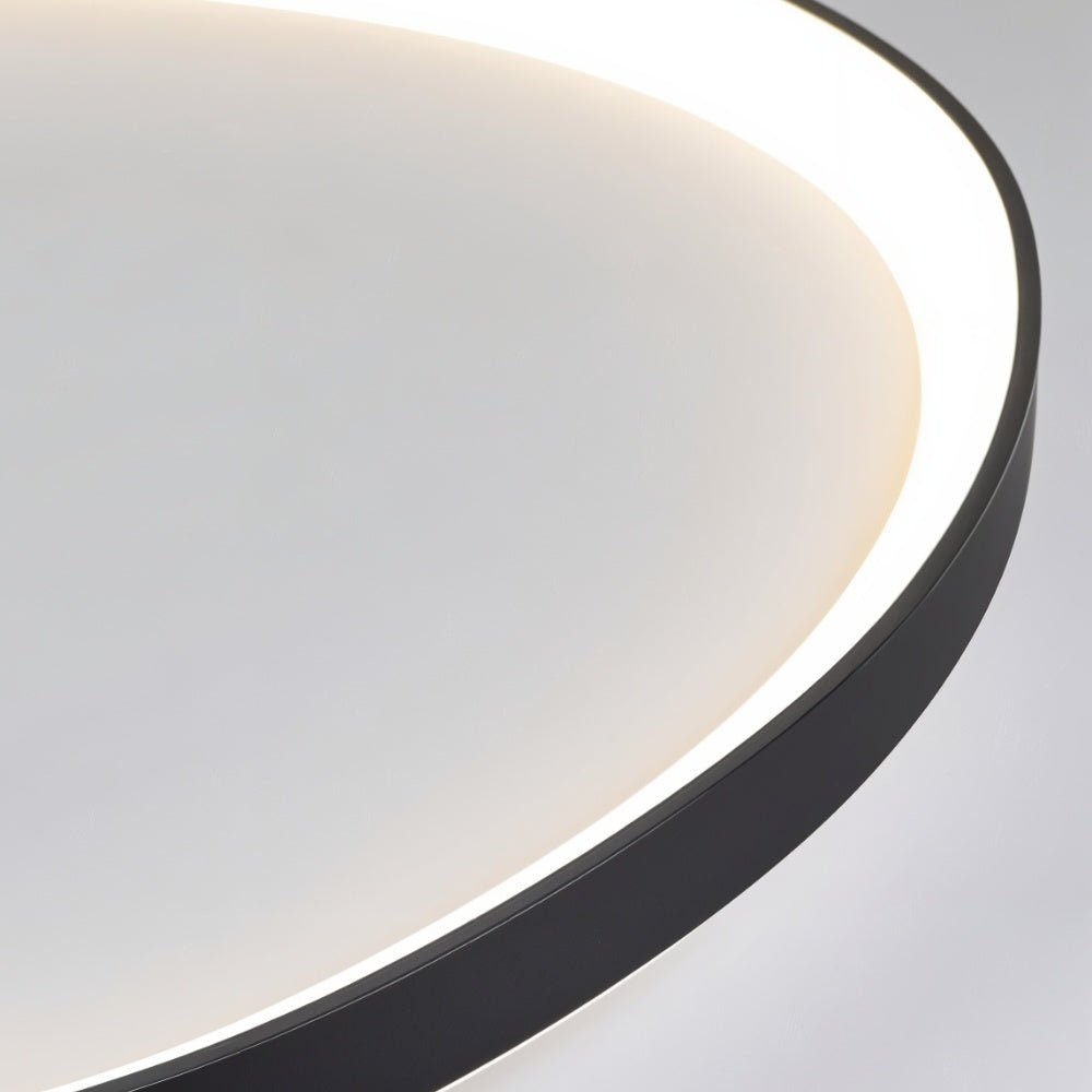 Close-up of the Clérachic black aluminium ceiling light rim, its slim edge framing a soft glowing white diffuser.