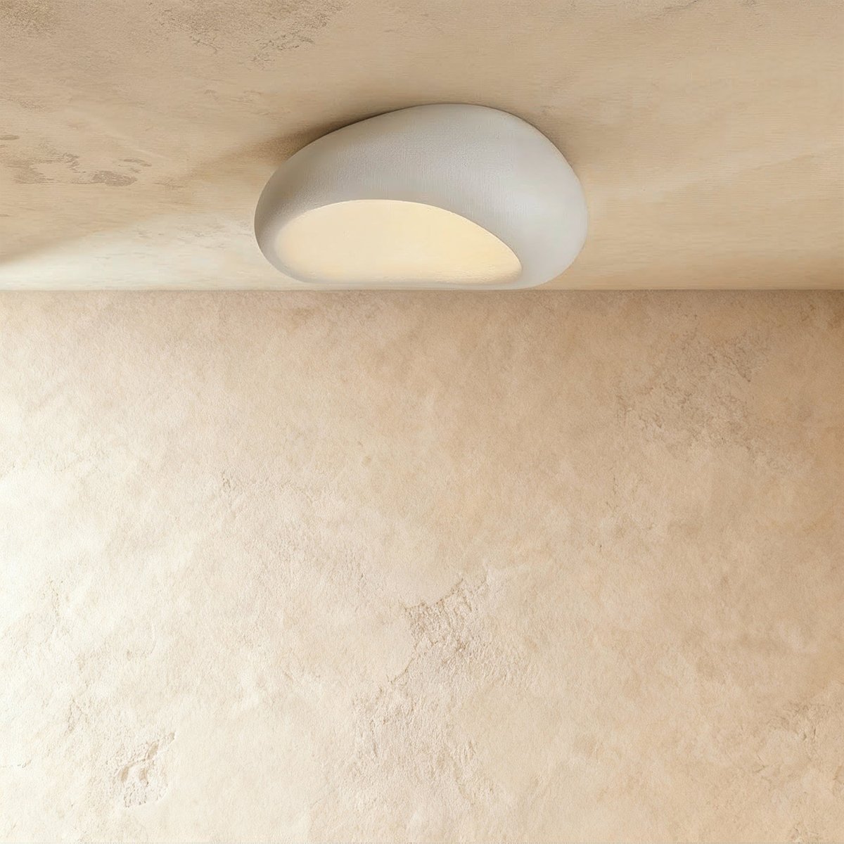 Clérachic matte white pebble flush light with a fine crackled texture, lit warm against a plaster ceiling.