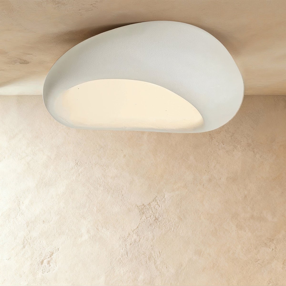 Clérachic largest white pebble flush ceiling light, its broad curved shell and warm lit opening filling the frame.