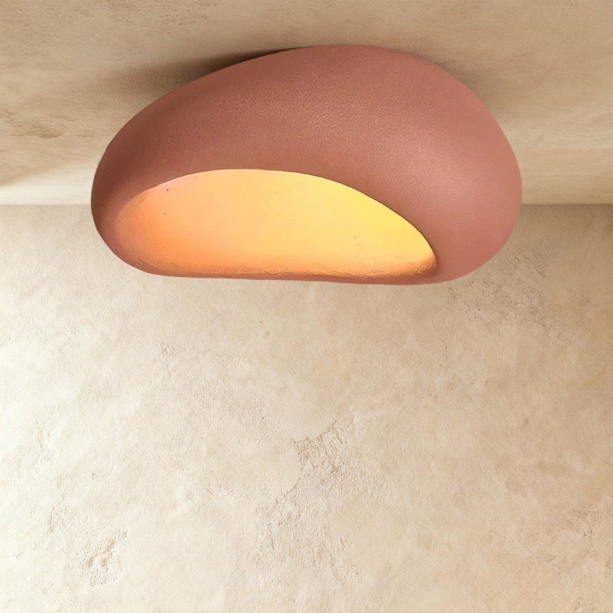 Clérachic extra-large terracotta pink pebble flush light, its matte shell and warm opening nearly filling the frame.