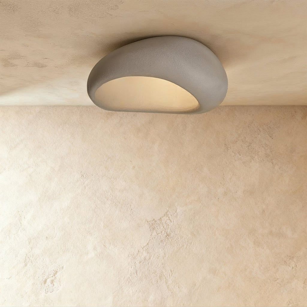 Clérachic larger grey pebble flush light with a matte mottled shell and a frosted, warmly lit opening.
