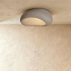 Clérachic larger grey pebble flush light with a matte mottled shell and a frosted, warmly lit opening.