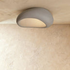 Clérachic wide grey pebble ceiling light with a fine matte texture and a pale, evenly glowing opening.