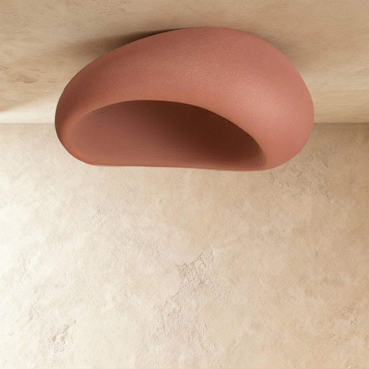 Clérachic large terracotta pink pebble ceiling light shown unlit, with a matte shell and a pink hollow interior.