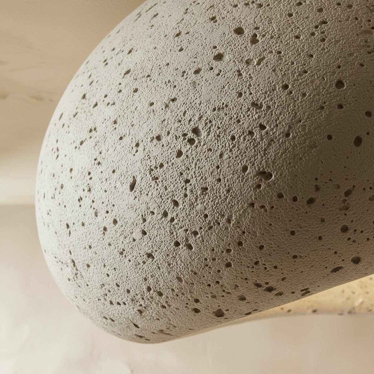 Close detail of the Clérachic cement-white shell, showing its porous, stone-like surface and a hint of lit interior.