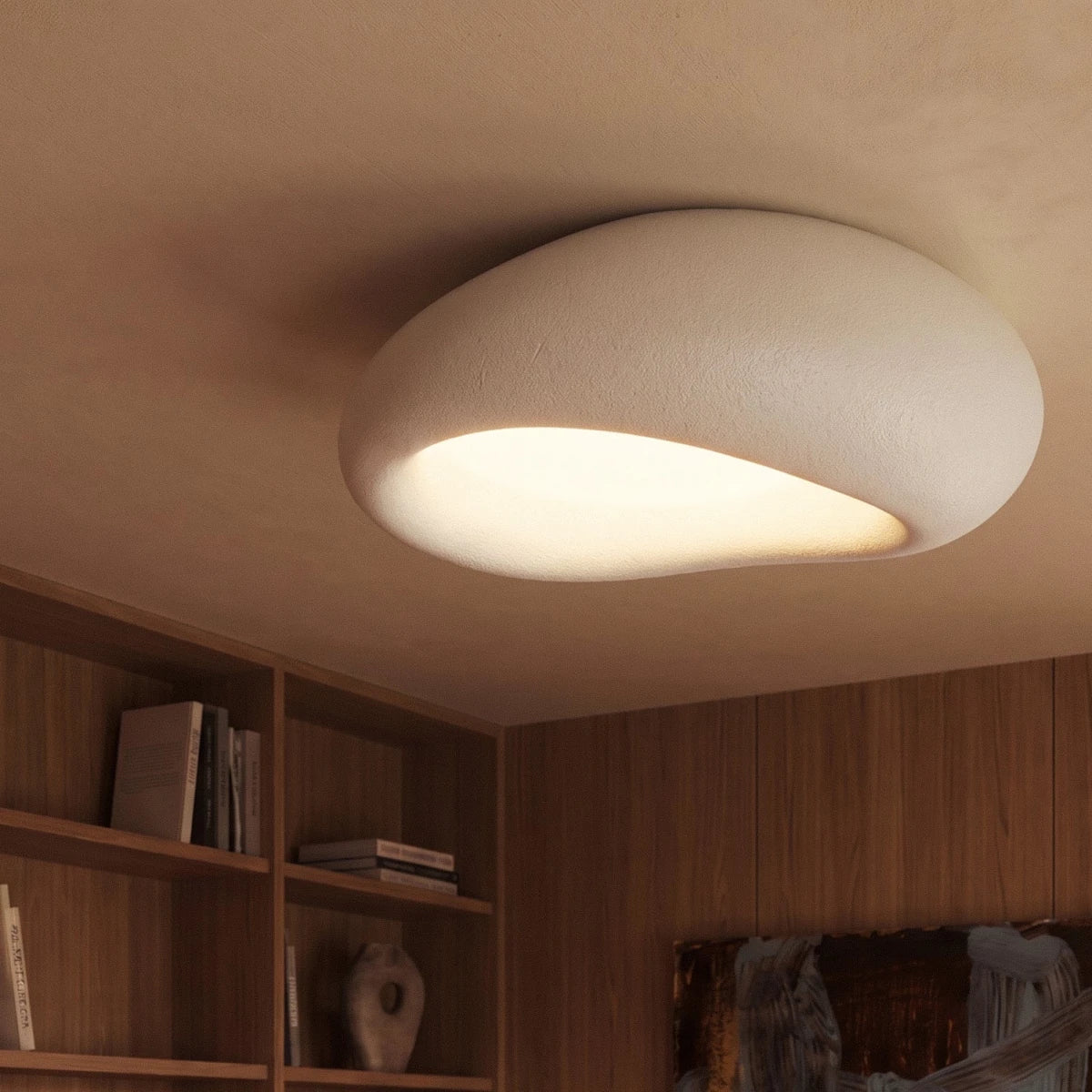 Clérachic white pebble ceiling light glowing warm over wood-panelled bookshelves in a study, seen from a low angle.