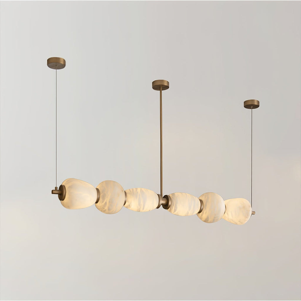 Clérachic Pebble chandelier on white, a row of alabaster forms threaded along a slim brass rod.