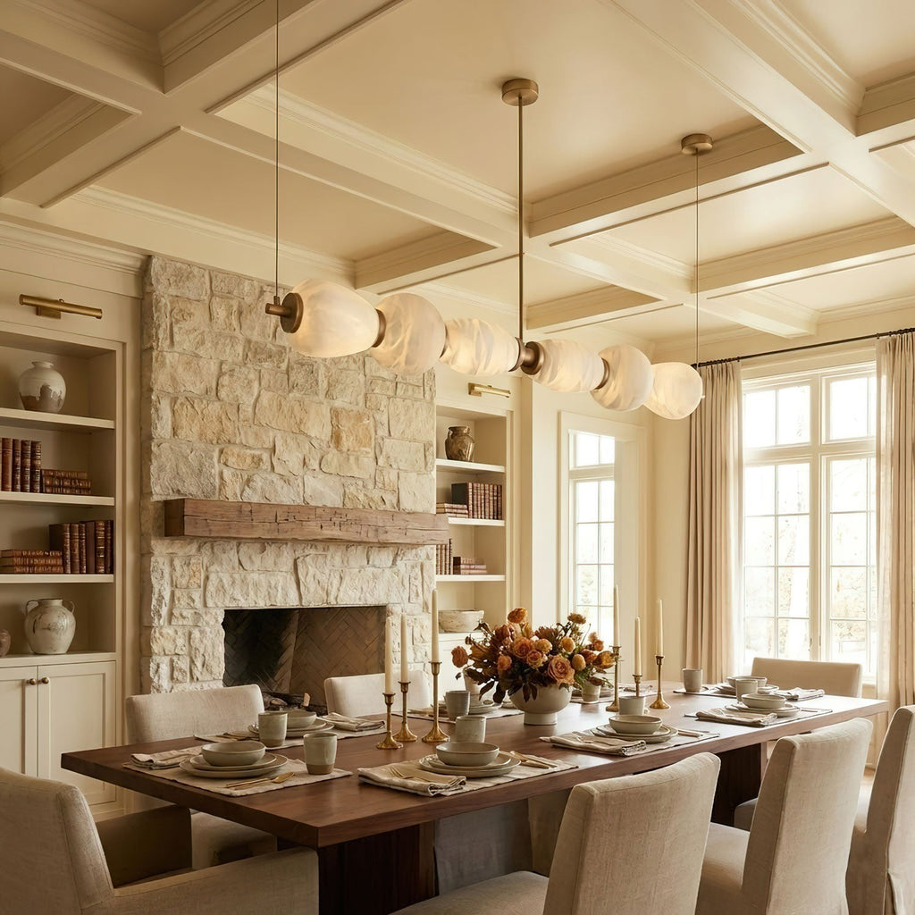 Clérachic Pebble chandelier above a set table beneath a coffered ceiling and stone fireplace.