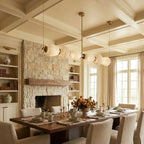 Clérachic Pebble chandelier above a set table beneath a coffered ceiling and stone fireplace.