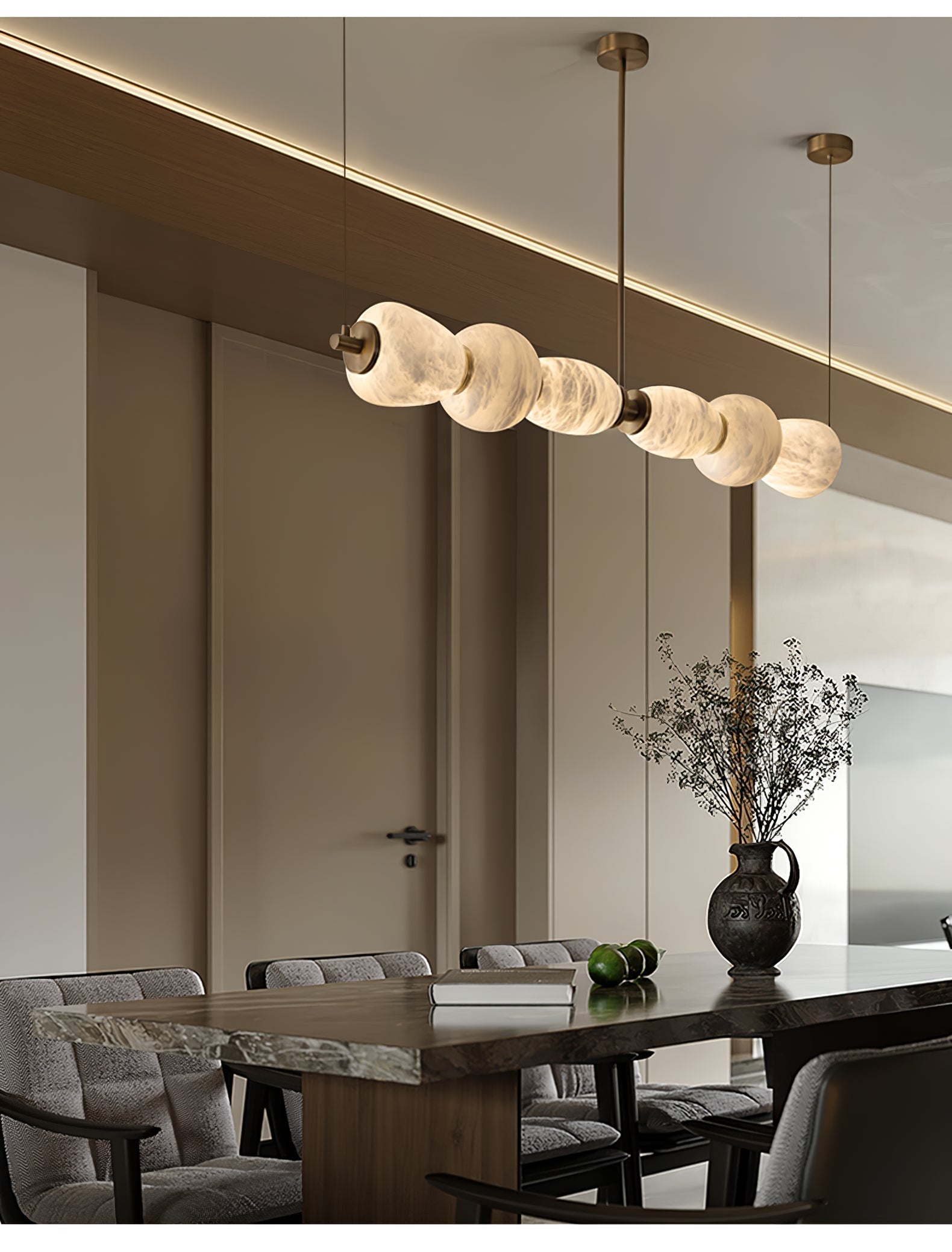 Clérachic Pebble chandelier above a dark dining table in a room lined with tall panelled doors.