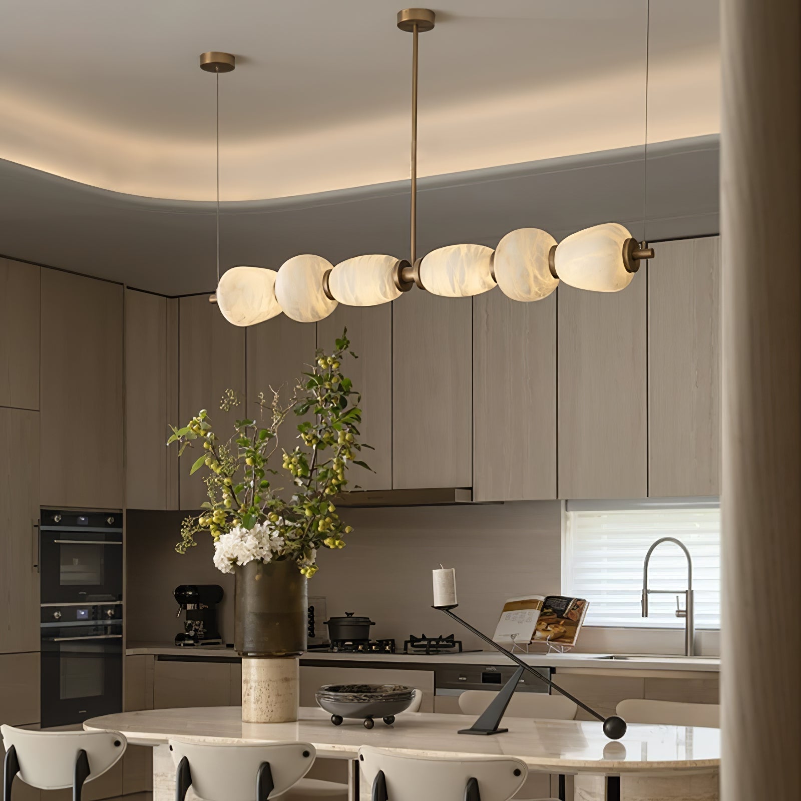 Clérachic Pebble chandelier seen close in an oak kitchen, alabaster forms glowing warm.